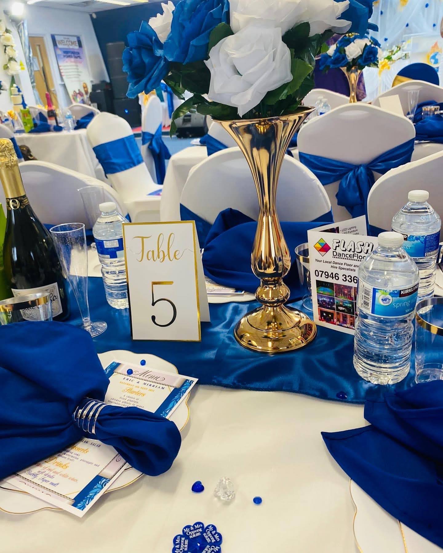 Gold vase and royal blue floral table arrangement
